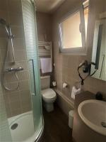 ein Bad mit einem WC, einem Waschbecken und einer Dusche in der Unterkunft Hotel Le Richemont in Paris