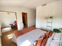 a bedroom with a large bed and a living room at Le Clos des Grands Frênes in Pons