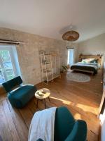 a living room with a bed and a table and chairs at Le Clos des Grands Frênes in Pons