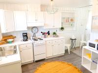 ガルフ・ショアーズにあるBudget Friendly Bungalow within Walking Distance to the Beach!の白いキャビネットとキッチンラグ付きのキッチン