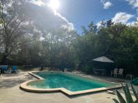 a swimming pool in a yard with chairs and an umbrella at Le Moulin du Carla in Lavaur