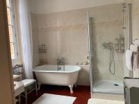 a white bathroom with a tub and a shower at Le Moulin du Carla in Lavaur