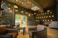 eine Lobby mit Stühlen und Tischen und einer Ziegelwand in der Unterkunft Nature Village Resort in Pushkar