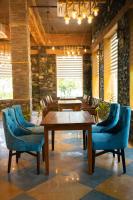 ein Esszimmer mit Holztischen und blauen Stühlen in der Unterkunft Nature Village Resort in Pushkar