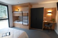 a bedroom with a bed and a desk and bunk beds at L&#39;Orée des Sources in Volvic