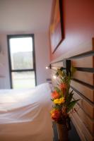 a bedroom with a bed and a vase of flowers at L&#39;Orée des Sources in Volvic