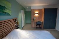 a bedroom with a bed and a desk with a chair at L&#39;Orée des Sources in Volvic