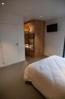 a bedroom with a bed and a flat screen tv at L&#39;Orée des Sources in Volvic