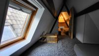 a small attic room with a window and a staircase at Rijksmonument Havenzicht, met zeezicht, ligging direct aan zee en centrum in Vlissingen