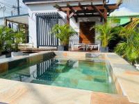 a swimming pool in front of a house at Bungalow Enjoy in Petit-Bourg