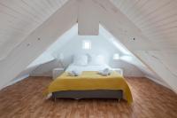 a bedroom with a yellow bed in a attic at AR PENNITI - Magnifique maison en pierre proche plage in Landéda
