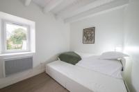 a white room with a couch and a window at AR PENNITI - Magnifique maison en pierre proche plage in Landéda
