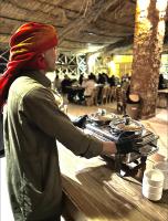 锡瓦Taghaghien Island Resort的一位女士站在带炉子的桌子旁边