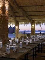 锡瓦Taghaghien Island Resort的一张长木桌,上面装有瓶装水