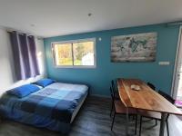 a bedroom with a bed and a wooden table at Studio indépendant climatisé in Veigné