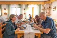 a group of people sitting at a table eating food at Auberge La maison de Catherine in Puy-Saint-Pierre