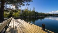 a wooden dock on a lake with trees and water at Villa Mustikka in Ekenäs