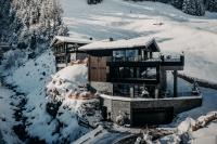 a house in the snow with snow on it at ONKL XONNA Premium Alpin Chalets in Hüttschlag