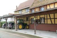 a tractor parked in front of a building at A la ferme in Kurtzenhouse
