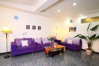 a living room with purple couches and a table at Ocean Sky Homestay in Toucheng
