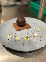 Un plato blanco con una bola de chocolate encima. en Hôtel Spa L'Oxygène, en Valmorel