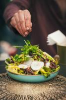 Una persona está preparando un plato de comida en una mesa. en Spice Quarter Inn, en Mitzpe Ramon