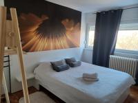 a bedroom with a bed and a large painting on the wall at Apartment M&amp;A in Osijek