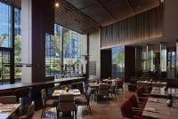 Un restaurante con mesas y sillas y grandes ventanales. en InterContinental Hangzhou Liangzhu by IHG, en Hangzhou