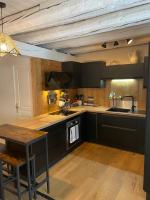 a kitchen with black cabinets and a wooden table at Le Chalet de Carole in Cadéac