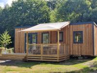 a wooden cabin with a porch and an awning at Camping Les Vosges du Nord in Oberbronn