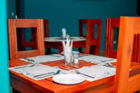 a wooden table with a plate and utensils on it at Kiteme Comfort Lodge in Arusha