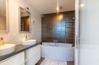 a bathroom with two sinks and a bath tub at Magnifique maison avec piscine a Gujan-Mestras in Gujan-Mestras