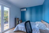 a bedroom with blue walls and a bed with a chair at Magnifique maison avec piscine a Gujan-Mestras in Gujan-Mestras