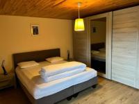 a bedroom with a bed with white sheets and a mirror at Lovely holiday home in Gouvy with sauna in Gouvy