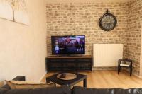 - un salon avec une télévision et un mur en briques dans l&#39;établissement Votre confort la Cosy Cocoon, à Courcouronnes