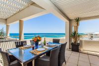 Una mesa y sillas en un balcón con vista al mar. en Beach View Apartment in Cottesloe, en Perth