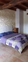a large bed in a bedroom with a stone wall at Domaine Lagardelle Rocamadour in Rocamadour