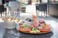 einen Teller mit Speisen und Weingläsern auf dem Tisch in der Unterkunft Wine-barrel Pinot-Gris in Dreischor