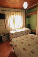 a bedroom with two beds and a window at Pousada Sino dos Ventos in Campos do Jordão