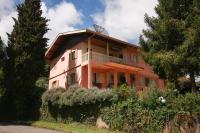 an orange building with a balcony on top of it at Pousada Sino dos Ventos in Campos do Jordão