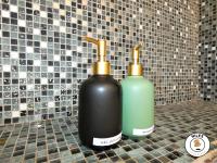 two black and green bottles sitting on a bathroom counter at La Caze Paloise ~ Atypique ~ 100% Fonctionnel in Pau