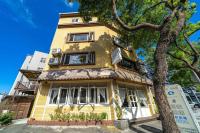 a yellow house with a tree in front of it at Hejia B&amp;B in Hualien City