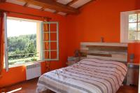 a bedroom with orange walls and a bed and two windows at Mas Chamarel à Sanary-sur-Mer au milieu des vignes et oliviers in Sanary-sur-Mer