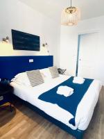 a bedroom with a large bed with blue and white sheets at Hôtel Jules in Le Touquet-Paris-Plage