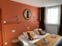 a bedroom with orange walls and a bed with a mirror at Hôtel Jules in Le Touquet-Paris-Plage