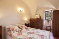 a bedroom with a bed and a dresser and a mirror at Casuccia in Santo-Pietro-di-Tenda