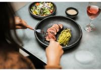 a person eating food on a table with a plate of food at Socialtel Parque 93 Bogota in Bogotá