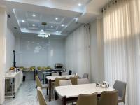 een eetkamer met tafels en stoelen en een keuken bij Hotel Nova in Bisjkek