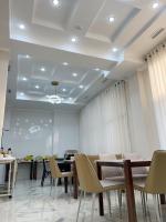 een wachtkamer met stoelen en tafels en een plafond bij Hotel Nova in Bisjkek