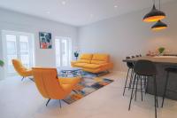 a living room with orange chairs and a table at NAPOLEON Luxurious renovated apartment 1min from Palais in Cannes